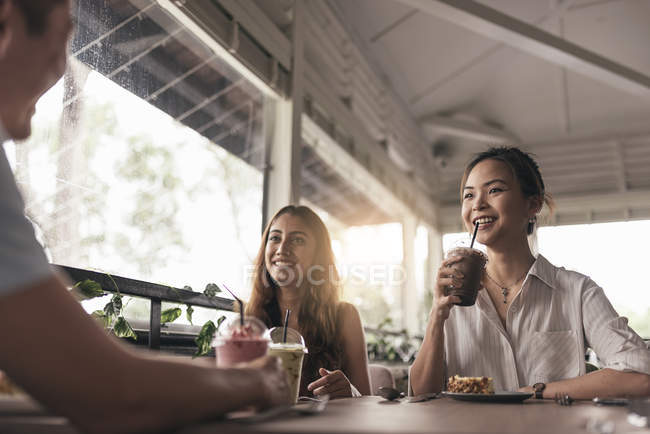 Grupo de amigos en un restaurante y bebidas - foto de stock