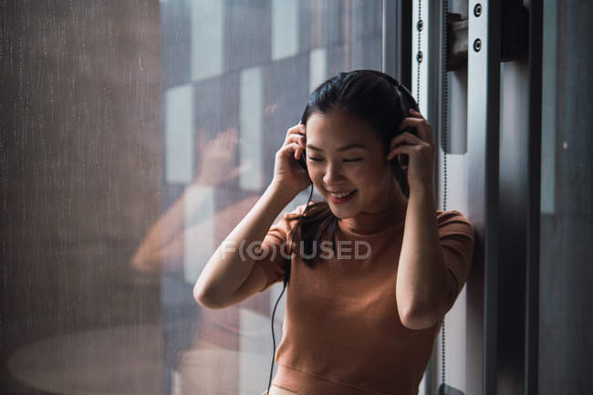 Mujer de negocios adulta joven usando auriculares - foto de stock