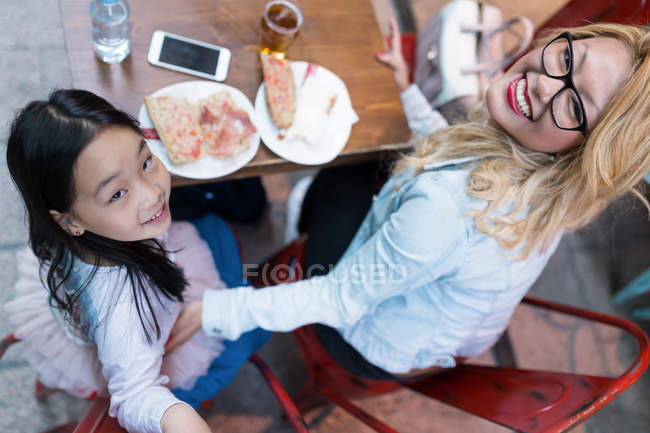Glückliche junge Mutter mit ihrer Tochter, die in die Kamera schaut — Stockfoto