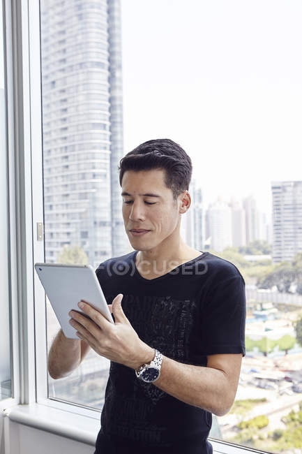 Красивый азиатский бизнесмен, работающий с планшетом в офисе — стоковое фото