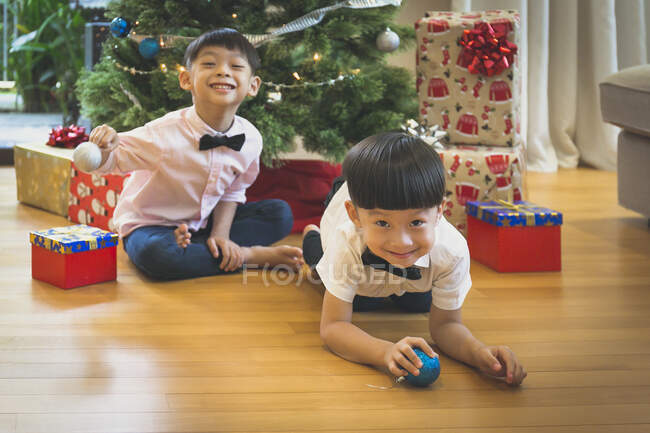 Hermanos jugando con la decoración del árbol de Navidad y divertirse. - foto de stock