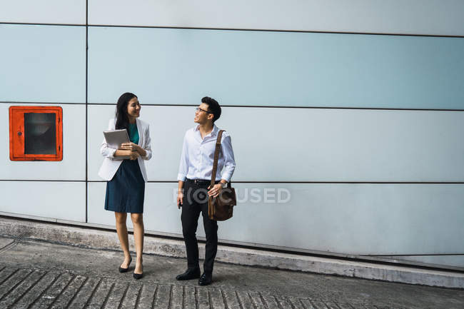Joven adulto negocio pareja caminar al aire libre - foto de stock