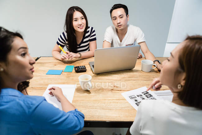 Giovani colleghi asiatici che lavorano insieme in ufficio moderno — Foto stock