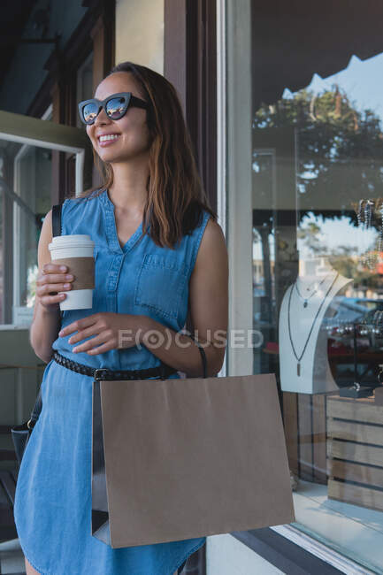 Bella donna shopping, bere caffè, e sorridente — Foto stock