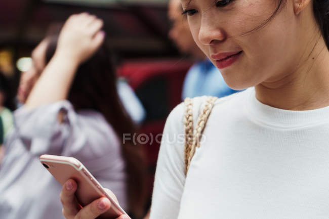 Joven atractivo asiático mujer usando smartphone - foto de stock