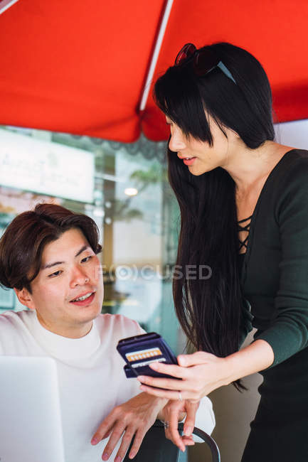 Joven asiático pareja compartir smartphone - foto de stock