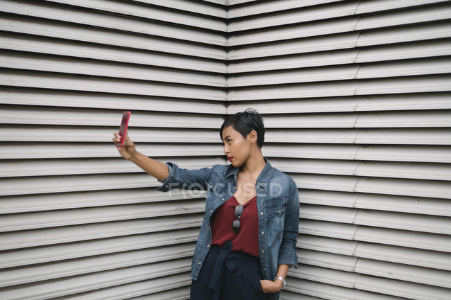 Молодая малайская сингапурская леди проводит портретную сессию с повторяющимися горизонтальными линиями в качестве фона . — стоковое фото
