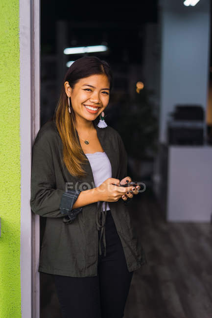 Jovem asiático mulher de negócios usando smartphone no escritório moderno — Fotografia de Stock