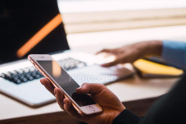 Cropped image of business person holding smartphone — Stock Photo