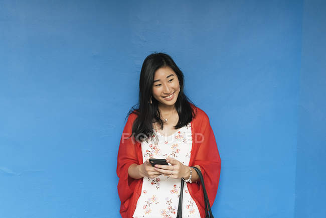 Азіатський жінка з довгим волоссям жінці за допомогою телефону — стокове фото