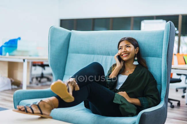 Joven asiático negocios mujer con smartphone en moderno oficina - foto de stock