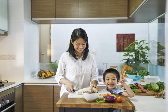 Felice giovane asiatico madre e figlio cucina insieme — Foto stock