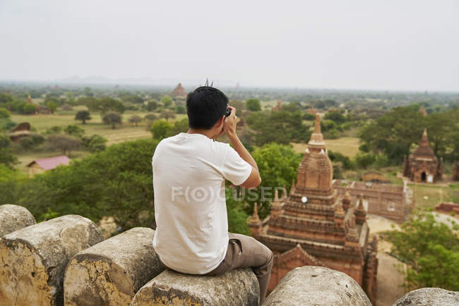 Молодой человек фотографирует на пагоде Швесандо (Баган, Мьянма) ) — стоковое фото