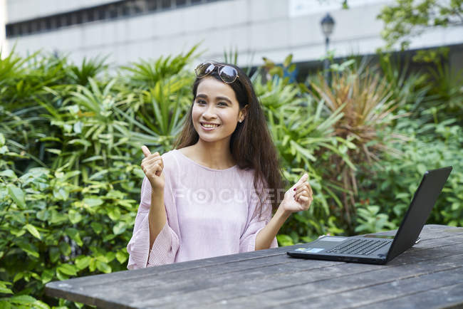 Heureuse jeune dame malaise sur son ordinateur portable en plein air — Photo de stock