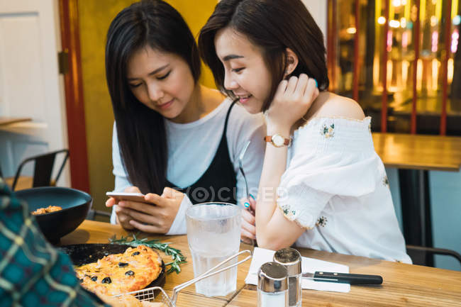 Giovani asiatiche amiche femminili in confortevole bar — Foto stock