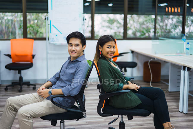 Young asian business people in modern office — Stock Photo