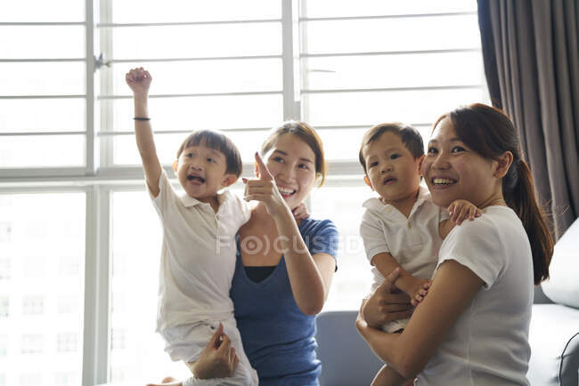 LIBERTA Mães jovens que se relacionam com seus filhos na sala de estar — Fotografia de Stock