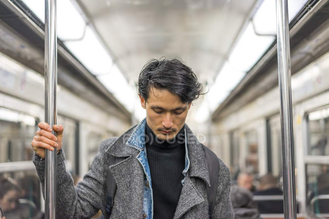 Joven atractivo casual asiático hombre en público transporte - foto de stock