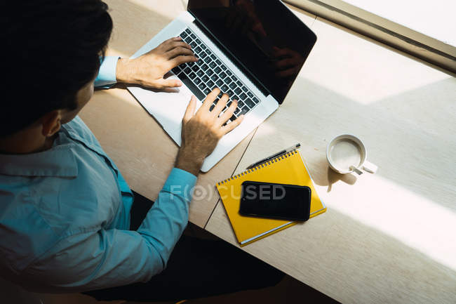 Hombre de negocios adulto joven que trabaja con el ordenador portátil en la oficina moderna - foto de stock