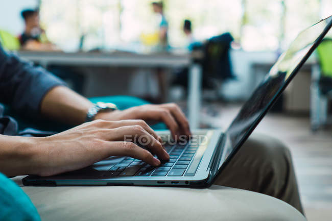 Image recadrée de l'homme d'affaires en utilisant un ordinateur portable dans le bureau — Photo de stock
