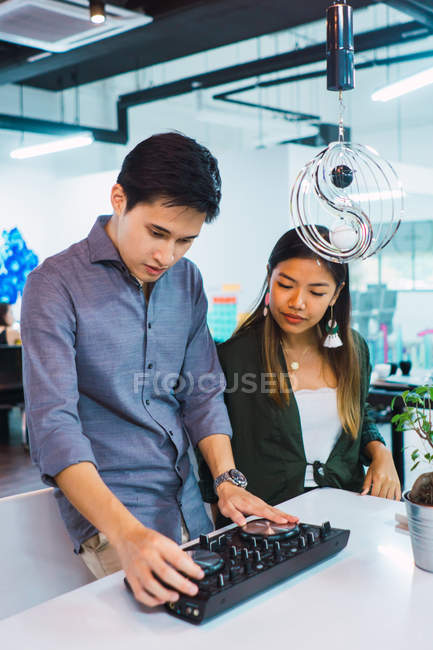 Jovem asiático negócios pessoas com dj dispositivo no moderno escritório — Fotografia de Stock
