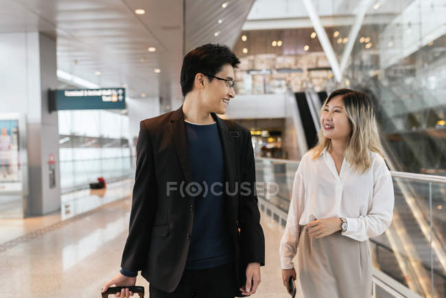 Молода азіатська пара бізнесменів, що ходять в аеропорту — стокове фото