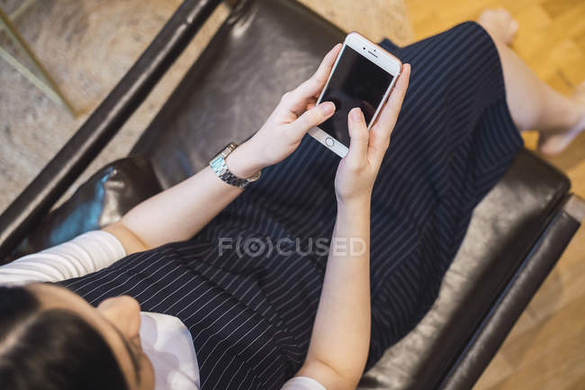 Young asian woman using smartphone in creative modern office — Stock Photo