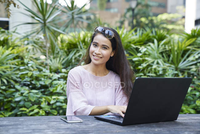 Jovem mulher bonita em seu laptop ao ar livre — Fotografia de Stock