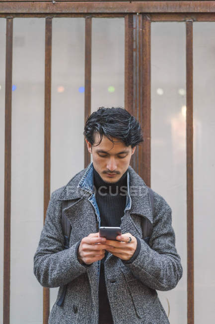 Joven atractivo casual asiático hombre usando smartphone - foto de stock