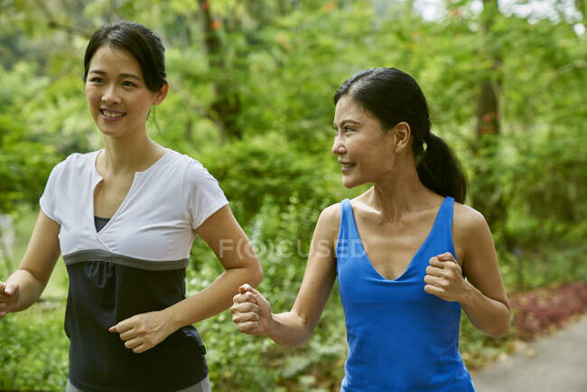 Две женщины бегут в Ботаническом саду, Сингапур — стоковое фото