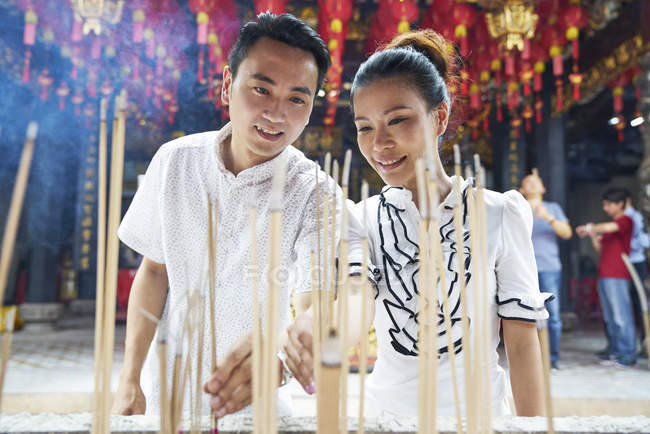 Joven y mujer en el templo. Singapur - foto de stock