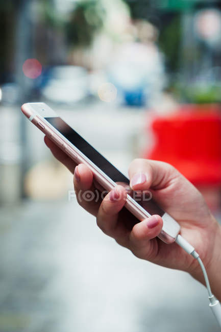 Обрізане зображення жінки, що тримає смартфон — стокове фото