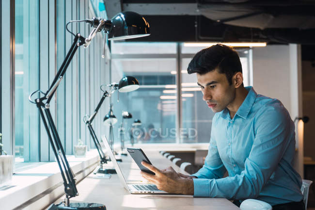 Молодой взрослый бизнесмен работает в современном офисе — стоковое фото
