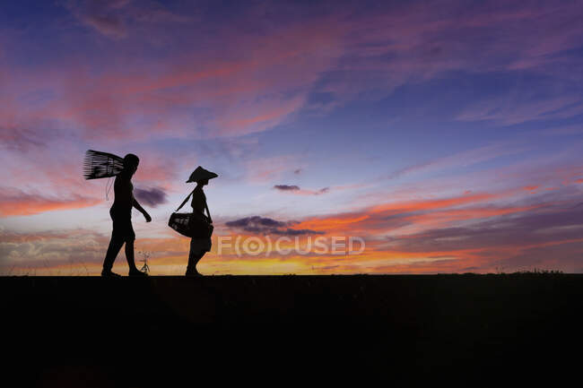 Image en silhouette des personnes au coucher du soleil. — Photo de stock
