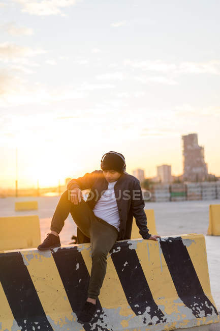 Junger asiatischer Millennial genießt den Sonnenuntergang mit Kopfhörern — Stockfoto