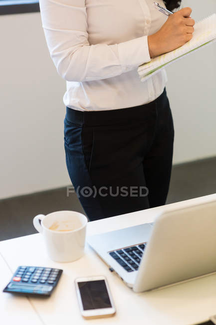 Cropped image of woman on workplace in modern office — Stock Photo
