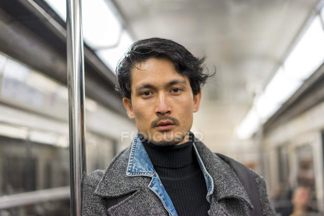Молодий привабливий випадковий азіатський чоловік в громадському транспорті — стокове фото