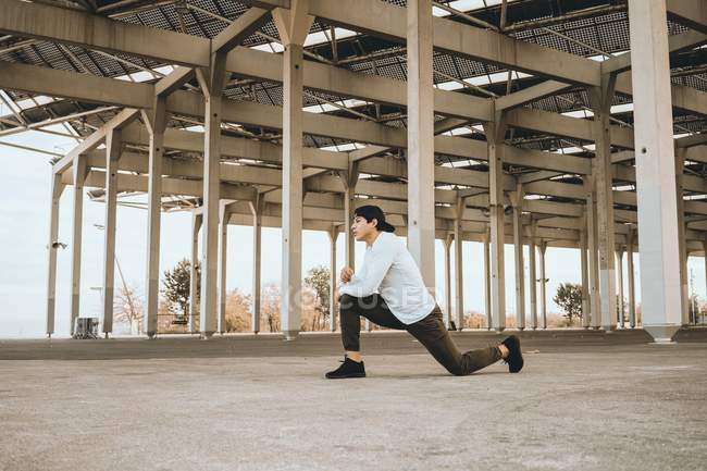 Young Asian man stretching outdoors — Stock Photo