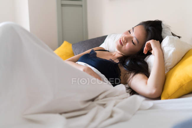 Chino joven y hermosa mujer despertando por la mañana - foto de stock