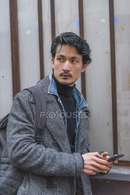 Jeune attrayant casual asiatique homme en utilisant smartphone — Photo de stock