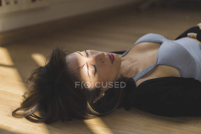 Joven asiático mujer acostado en suelo con cerrado ojos - foto de stock