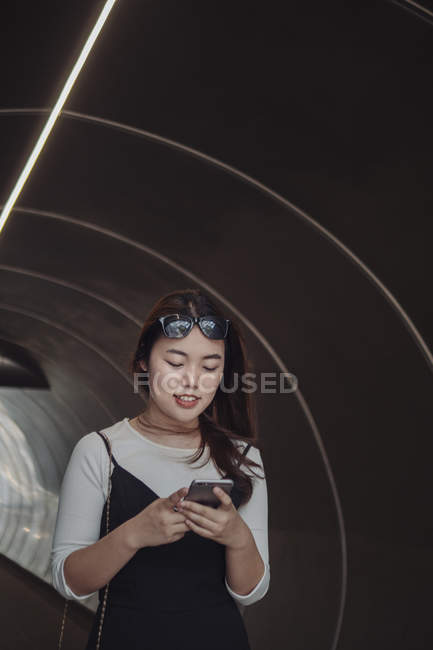 Mujer de pelo largo chino usando teléfono inteligente - foto de stock