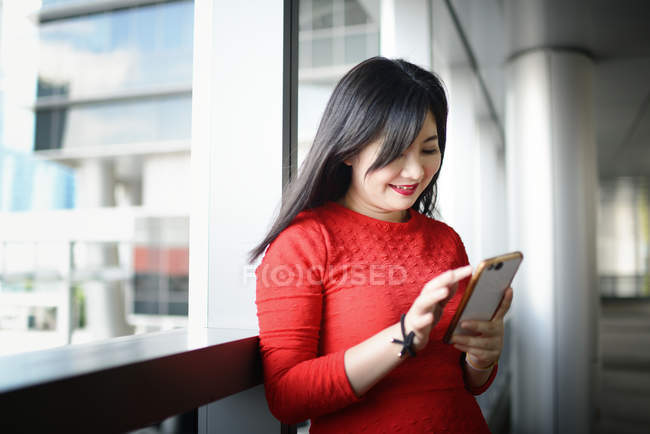 Junge schöne asiatische Frau mit Smartphone — Stockfoto