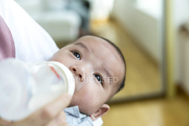 Mother feeding milk to her baby, closeup view — Stock Photo