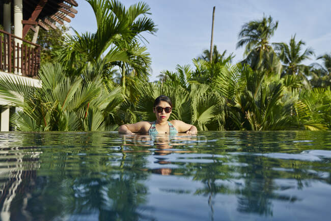 Mujer asiática joven relajante en la piscina - foto de stock