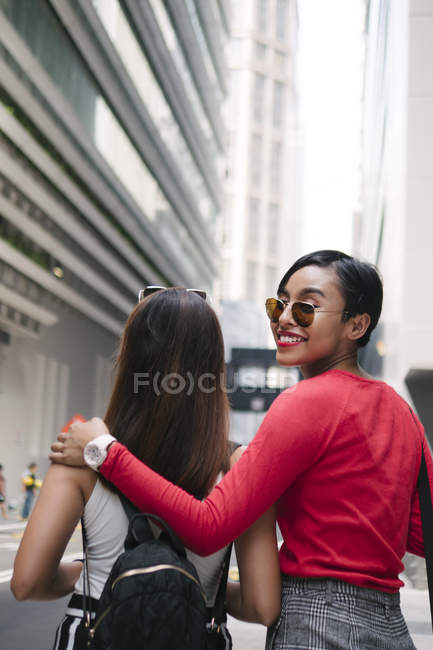 Young asian female friends walking on street — Stock Photo