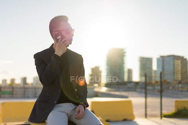 Young asian man using smartphone on parking lot — Stock Photo