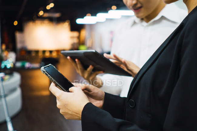 Молоді азіатські бізнесмени використовують цифрові пристрої в сучасному офісі — стокове фото