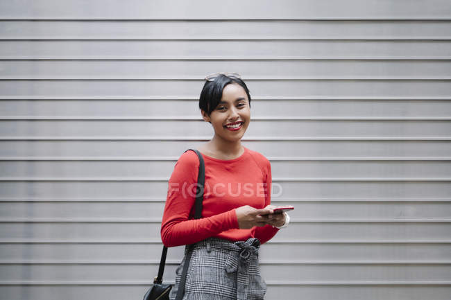 Молода азіатська приваблива жінка використовує смартфон — стокове фото