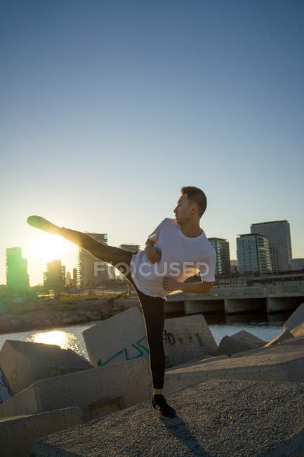 Молодий азіатський чоловік, показуючи сторону, стукає на відкритому повітрі — стокове фото